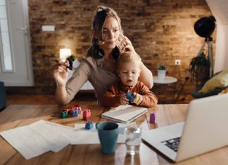 Facilita la vida de la mamá multitasking Multi-tasking mother babysitting her small son while working fro