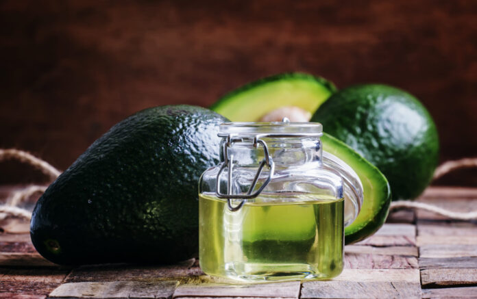 Avocado oil, old wooden background, selective focus